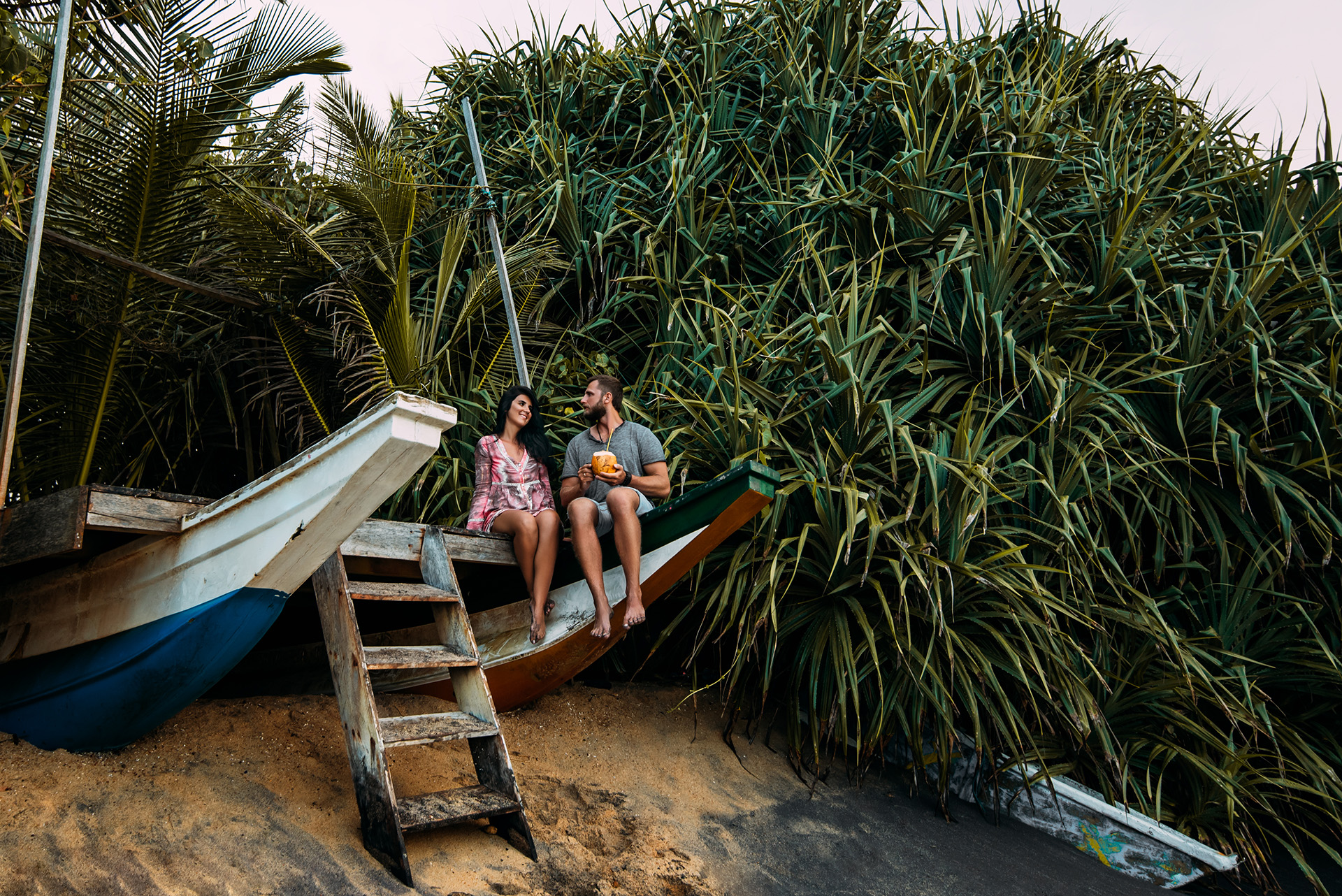 Honeymoon trip. Couple in love on the seaside drinking coconut. Couple on the shore of Paradise island. Man and woman in the Bali. Relax on the island. Holiday romance. Travel to Asia. Happy couple